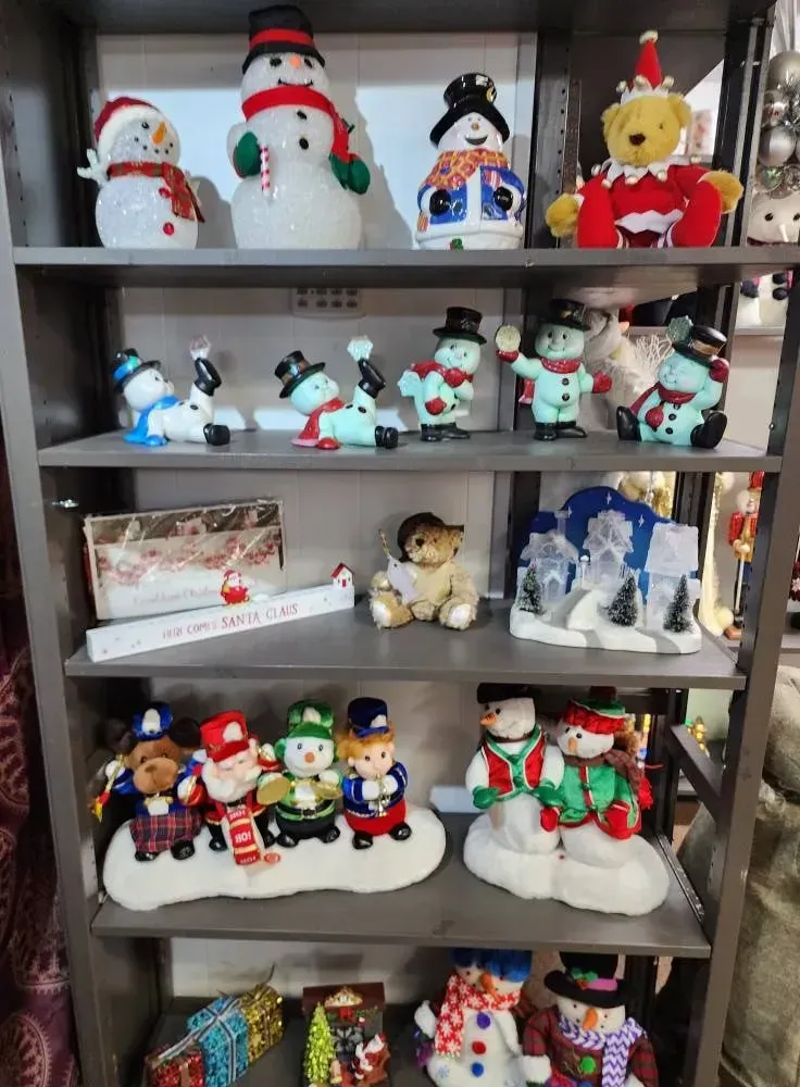 Shelves with Christmas-themed decorations: snowmen, Santa figures, and a teddy bear in a festive setting.
