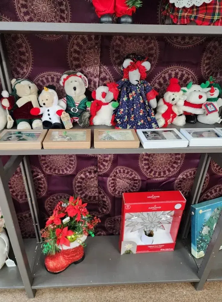 Shelves displaying holiday decorations including teddy bears, framed art, and ornaments.