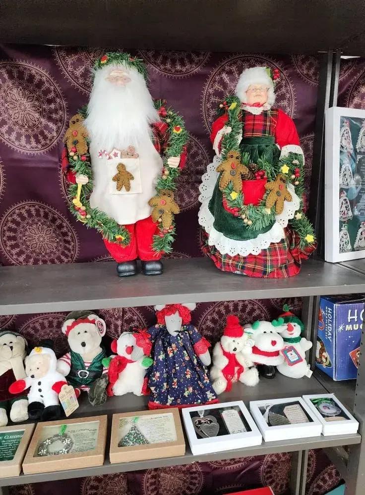 Christmas decorations on a shelf: Santa and Mrs. Claus figures, teddy bears, and framed ornaments.