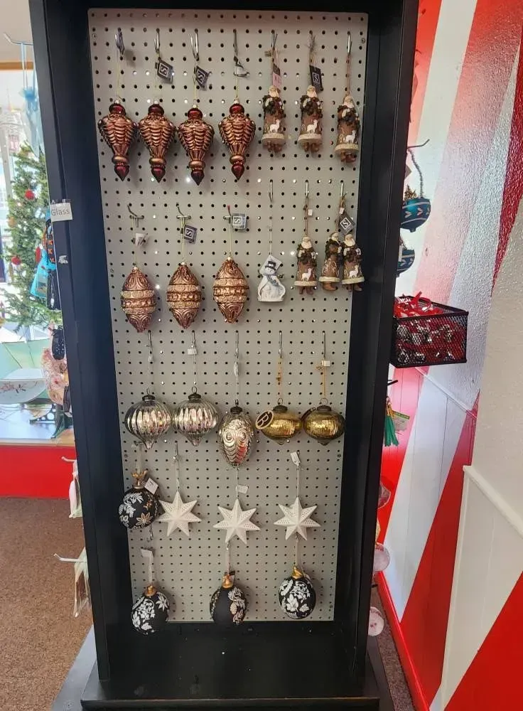 Display case of Christmas ornaments: copper, silver, and white stars and bells.