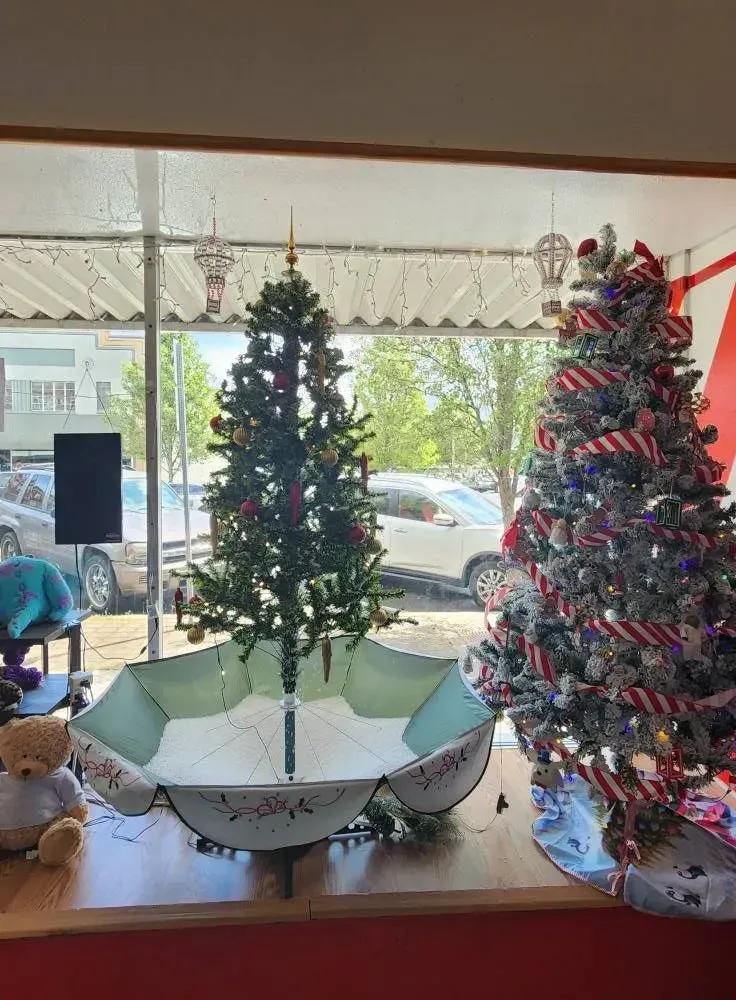 Christmas tree inside open umbrella, decorated tree, shop window display.