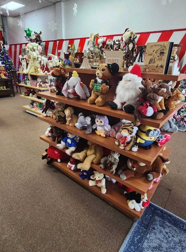 A wooden display shelf filled with plush toys in a store.