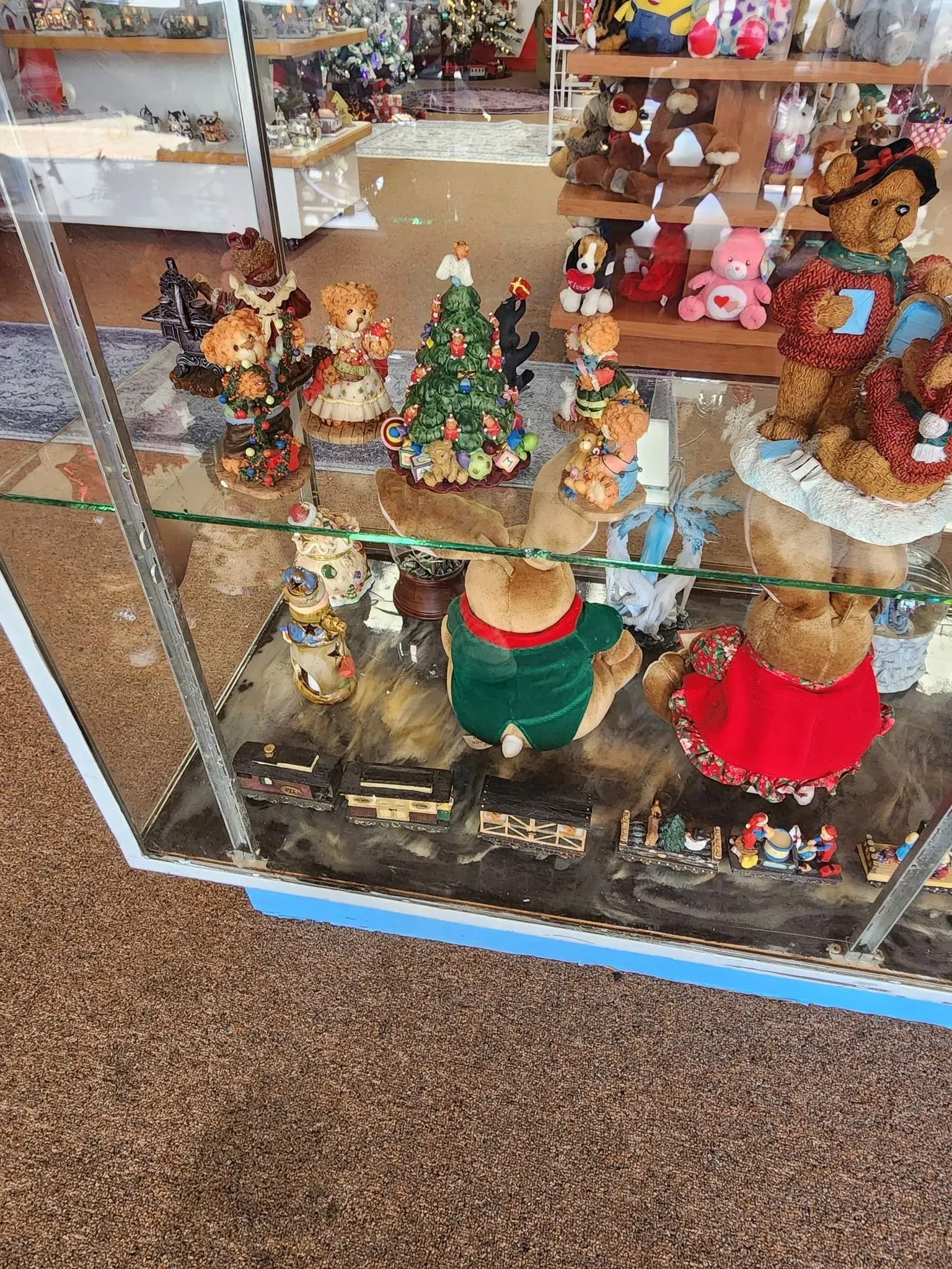 Display case with teddy bear figurines, including some with Christmas decorations.