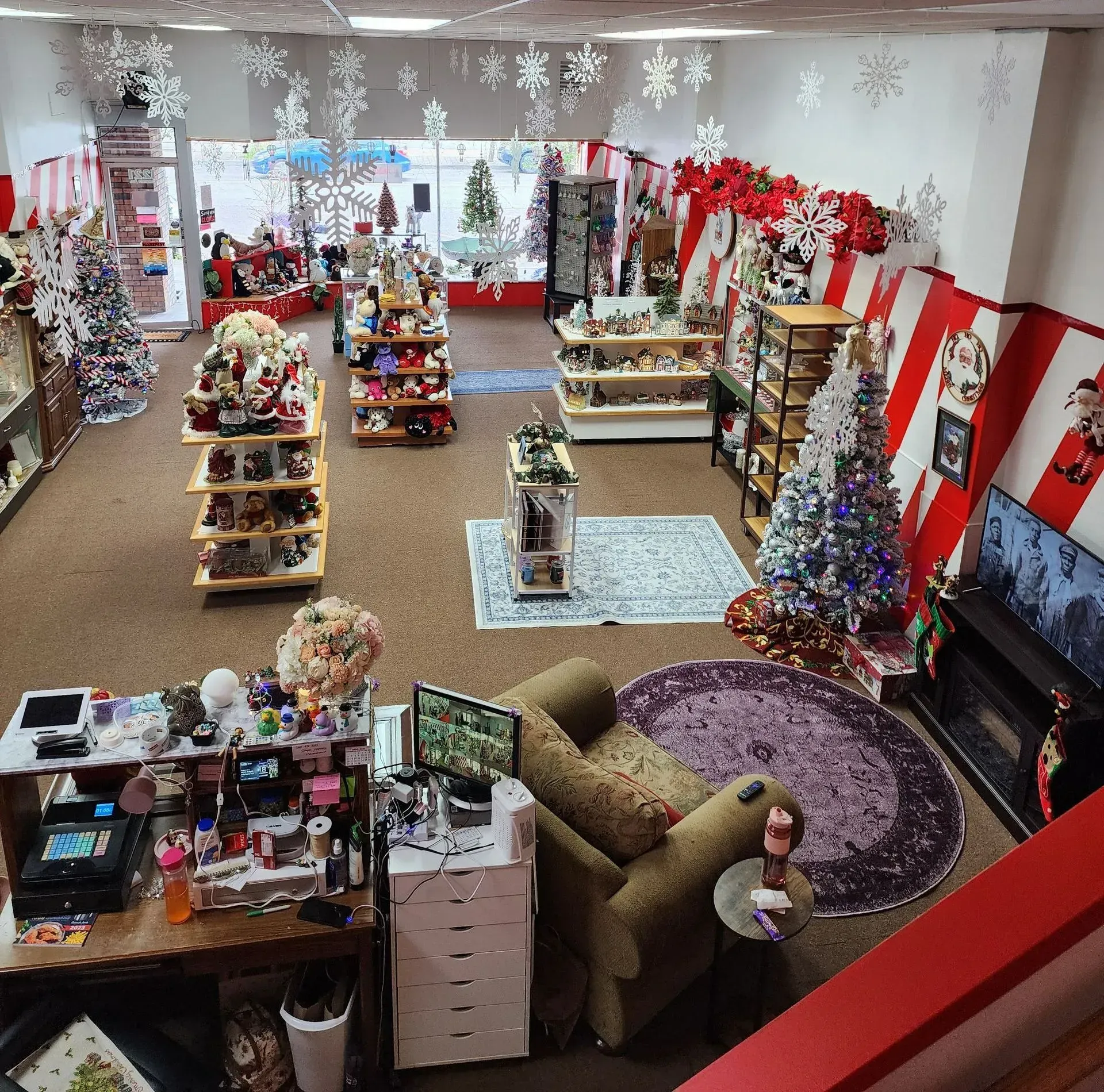 Interior of a store decorated for Christmas; featuring displays of ornaments, trees, and festive decorations.