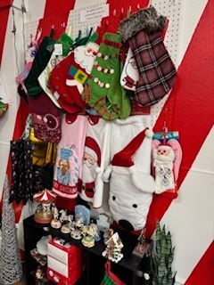 Christmas stockings and decorations displayed against a red and white striped wall.