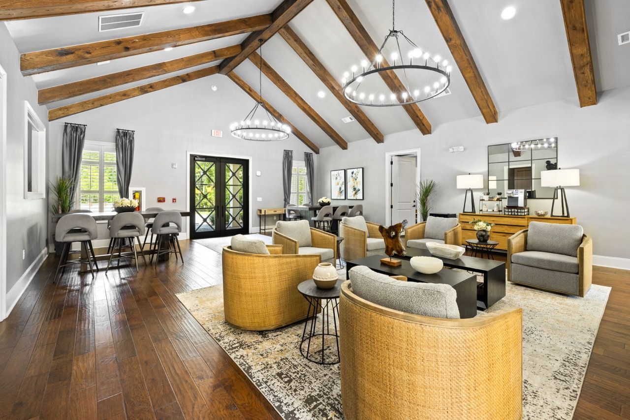 Spacious communal living area with wood-beam ceiling, lounge seating, and modern lighting.