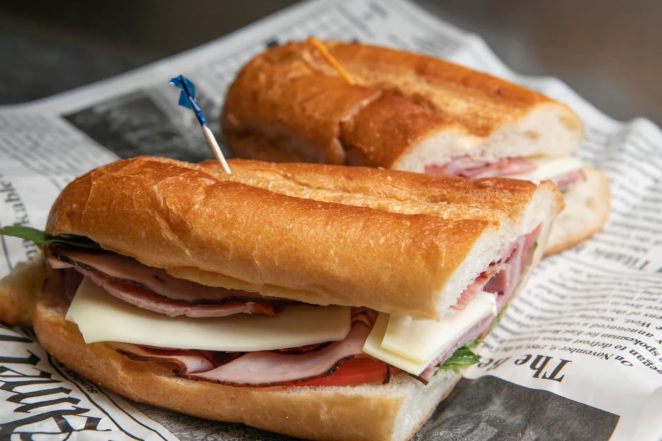 A margherita pizza with tomatoes, mozzarella cheese and basil on a metal pan.