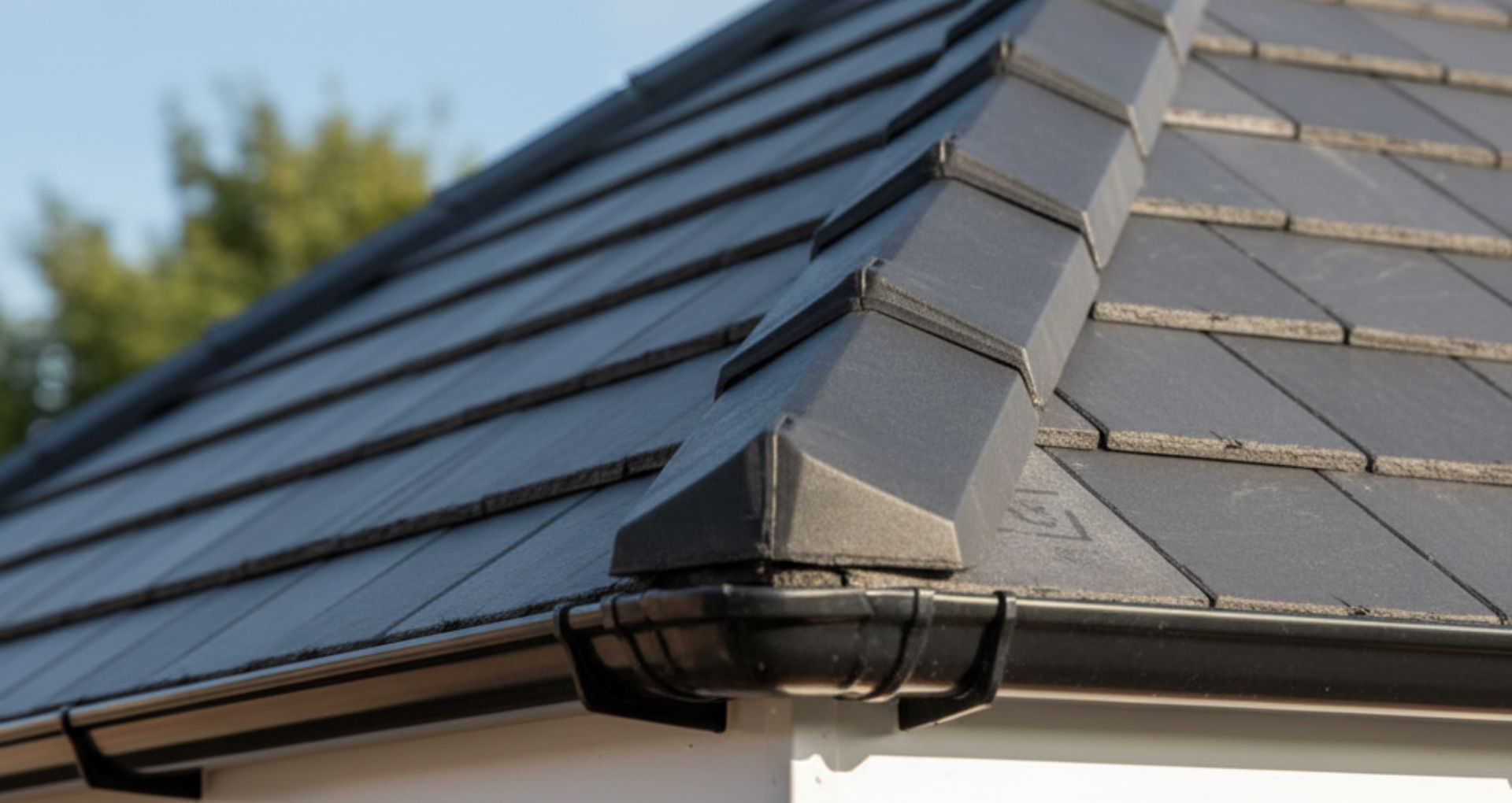Gray tiled roof with a dark gutter and a decorative corner piece.