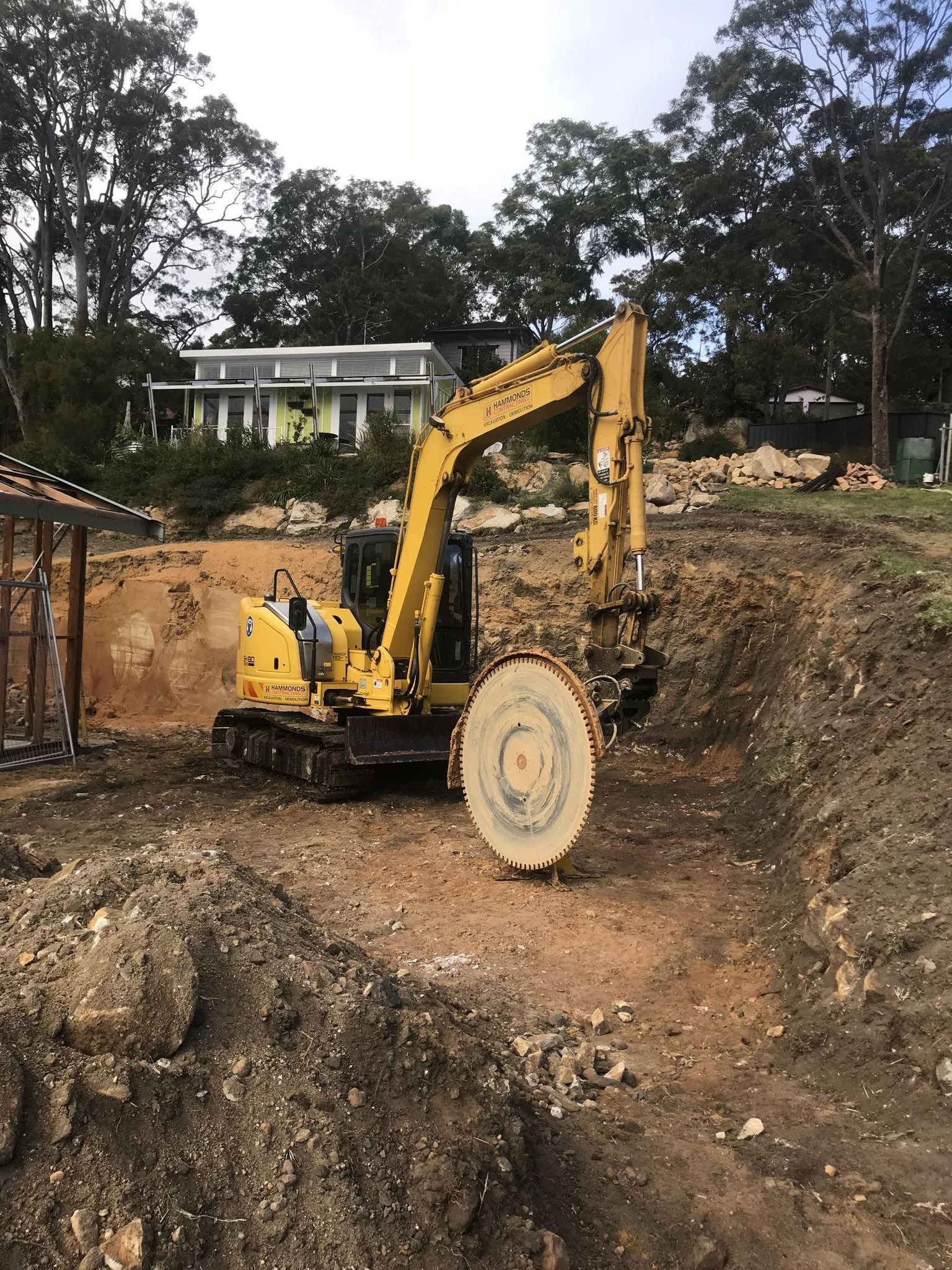 A yellow excavator is moving dirt on a construction site.