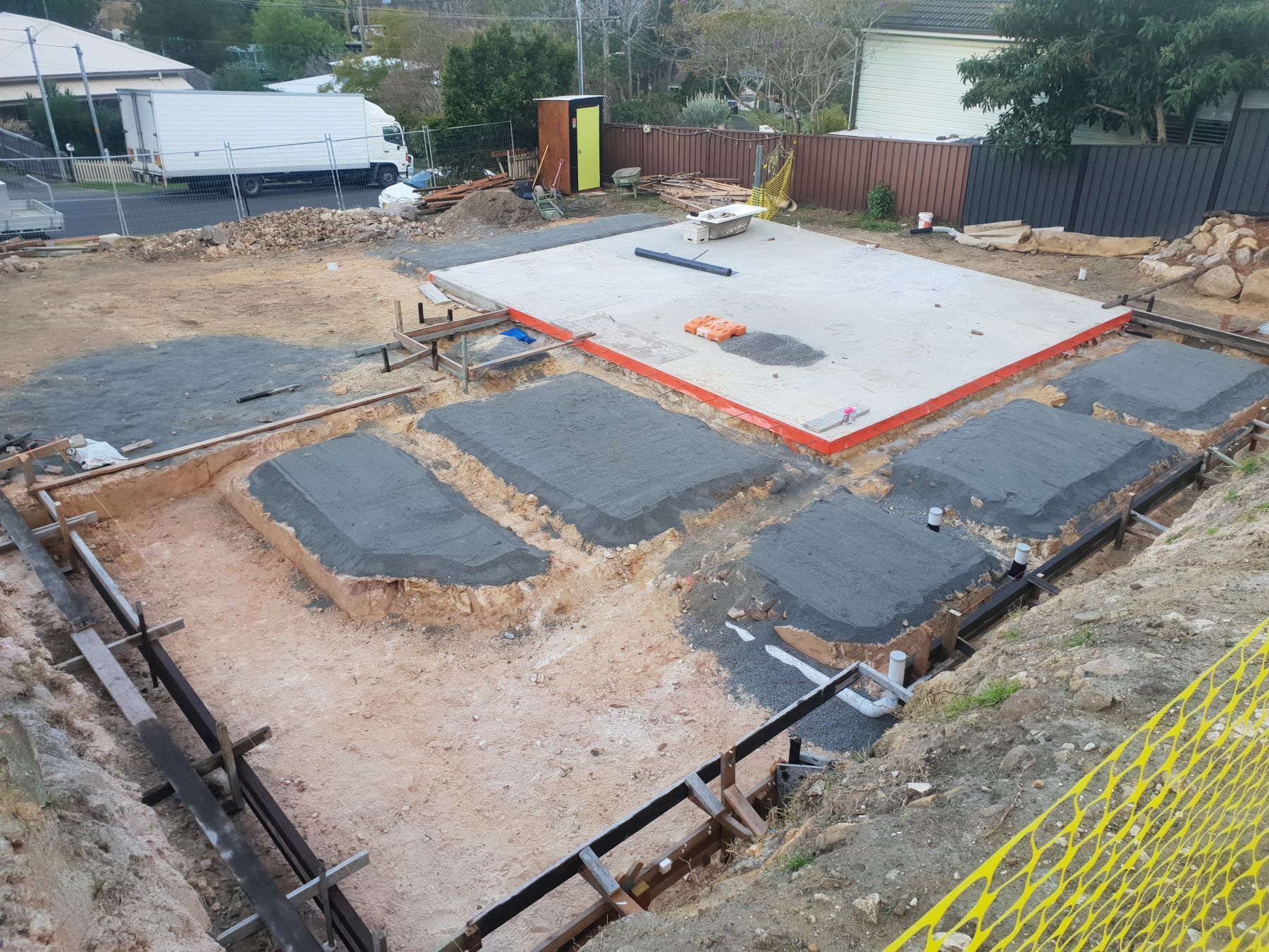 An aerial view of a construction site with a yellow fence in the foreground.