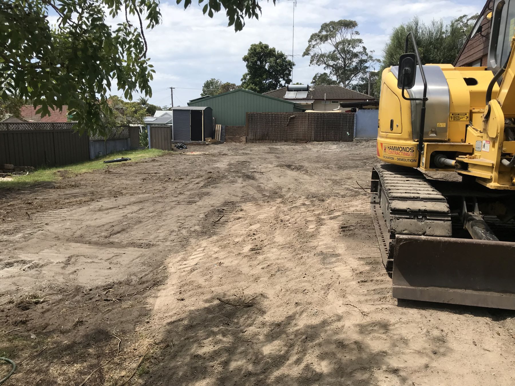 A yellow bulldozer is sitting in the middle of a dirt field.