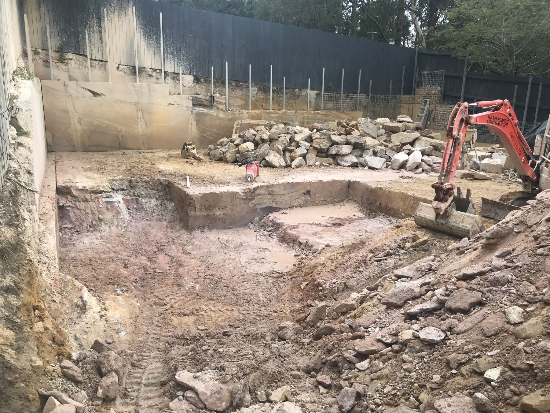 An excavator is digging a hole in the dirt in a construction site.