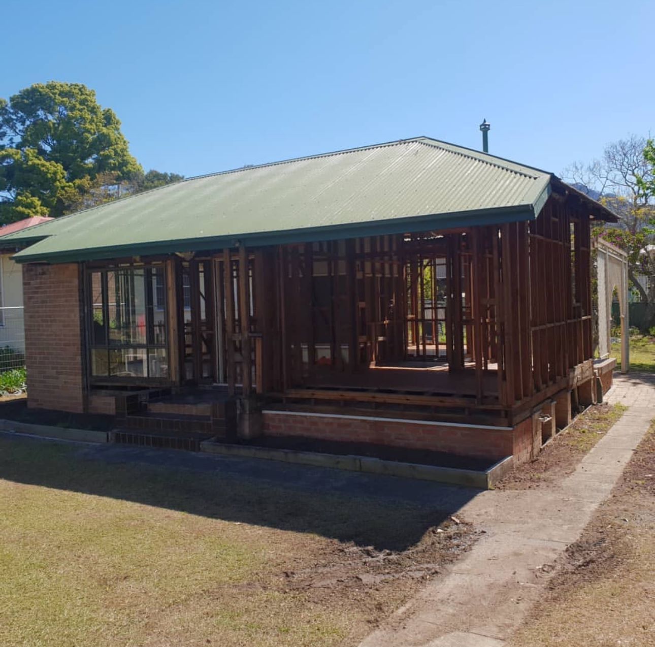 A small house with a green roof is being built.