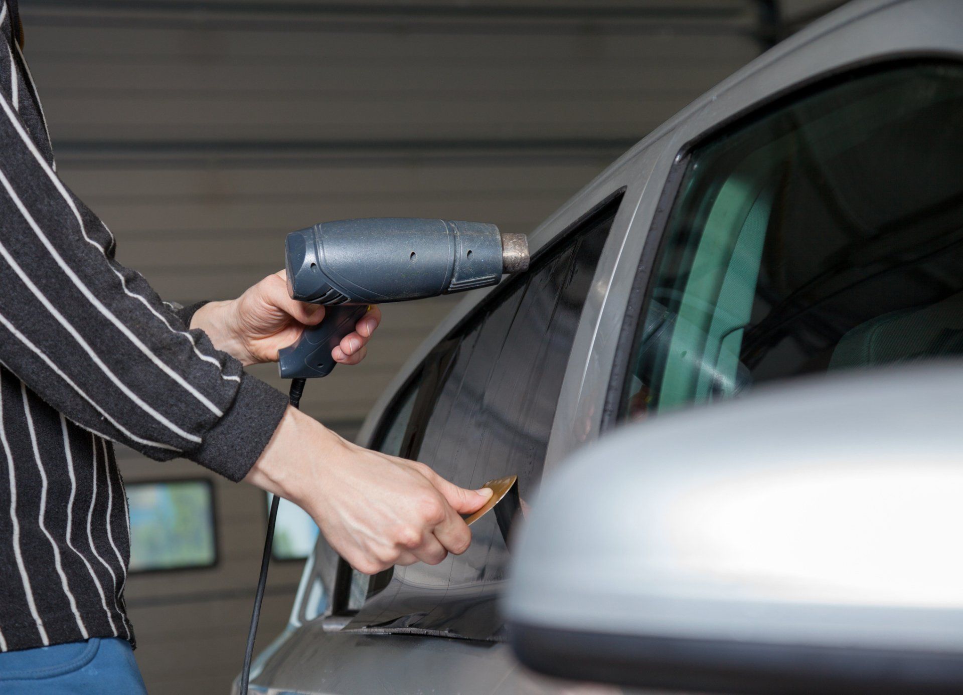 Car Stereo Installation — Applying Tinting Foil on a Car Window in Houston, TX