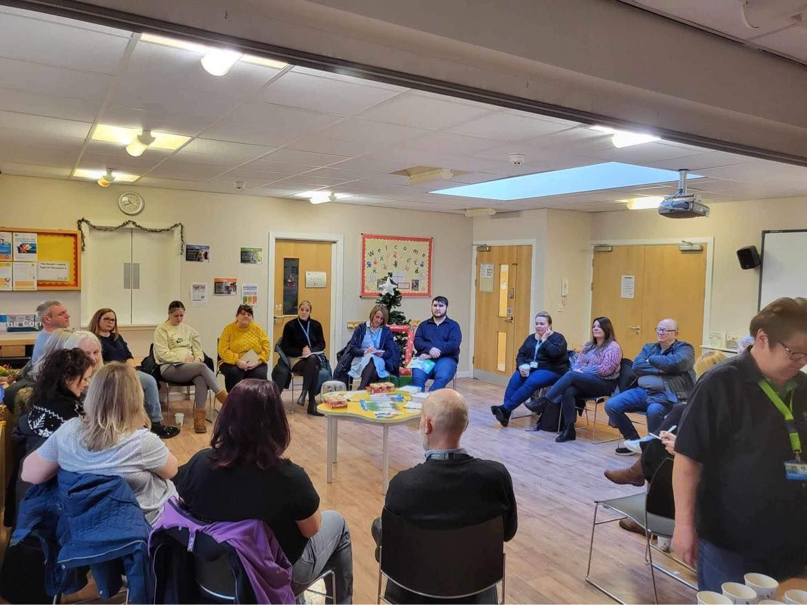 A group of people are sitting in a circle in a room.