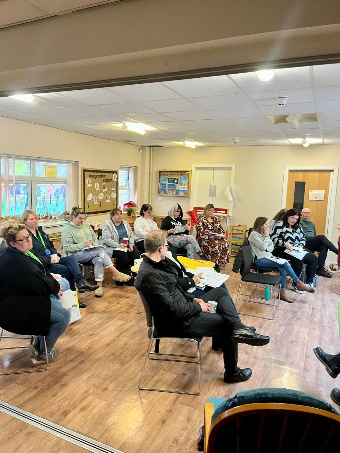 A group of people are sitting in chairs in a room.