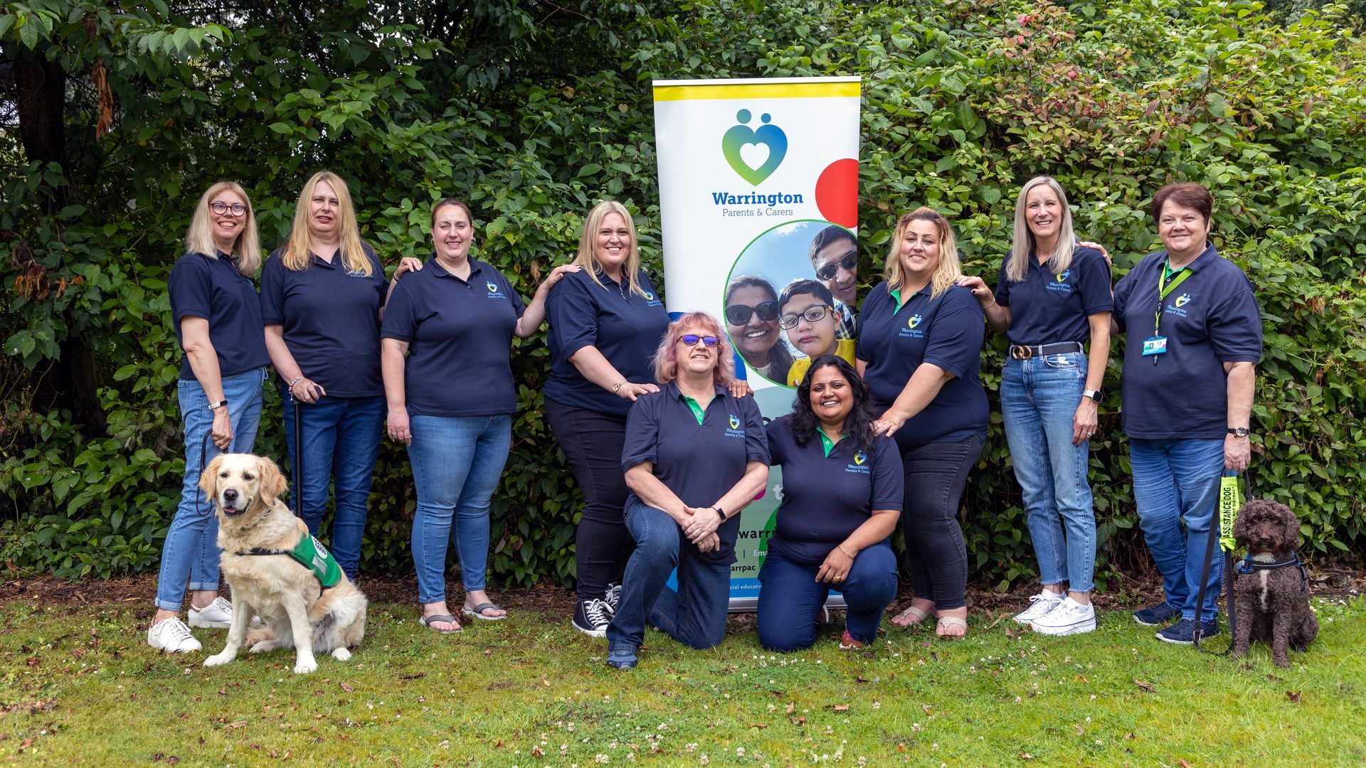 A group of people and a dog are posing for a picture.