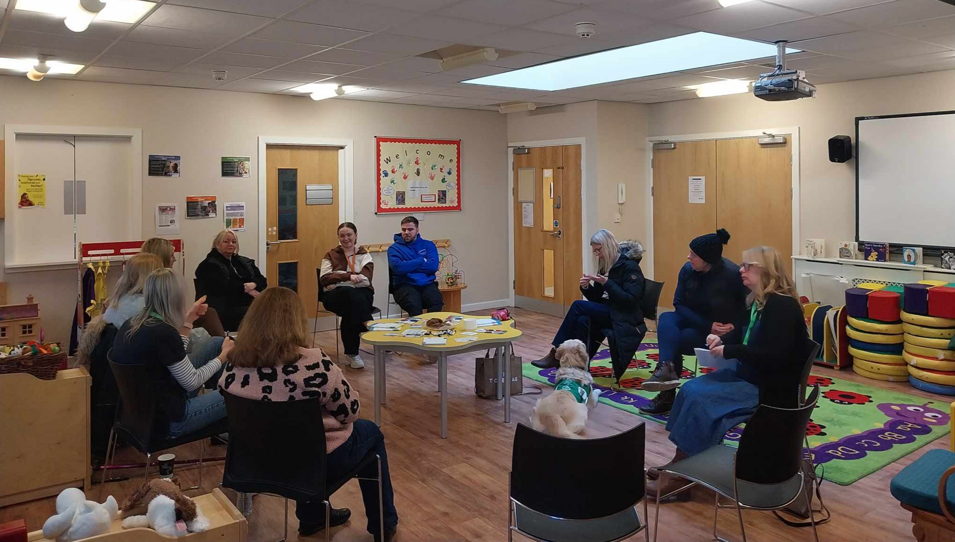 A group of people are sitting around tables in a room.