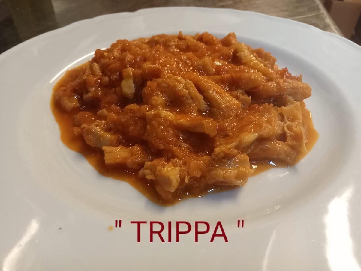 Un piatto bianco con scritto trippa sopra