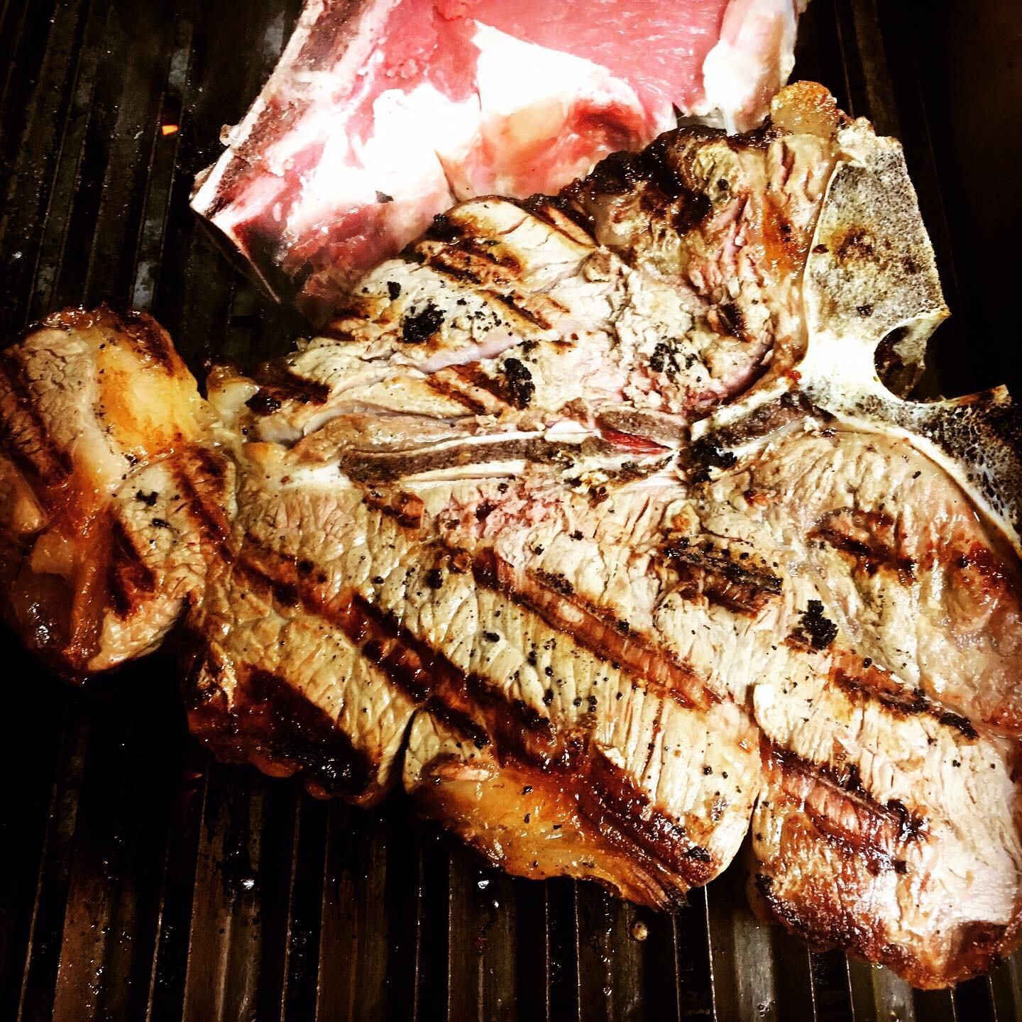 Un grosso pezzo di carne sta cuocendo su una griglia