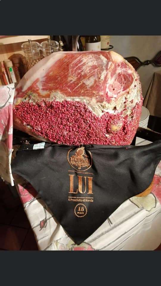 Un grosso pezzo di carne è appoggiato su un panno nero su un tavolo.