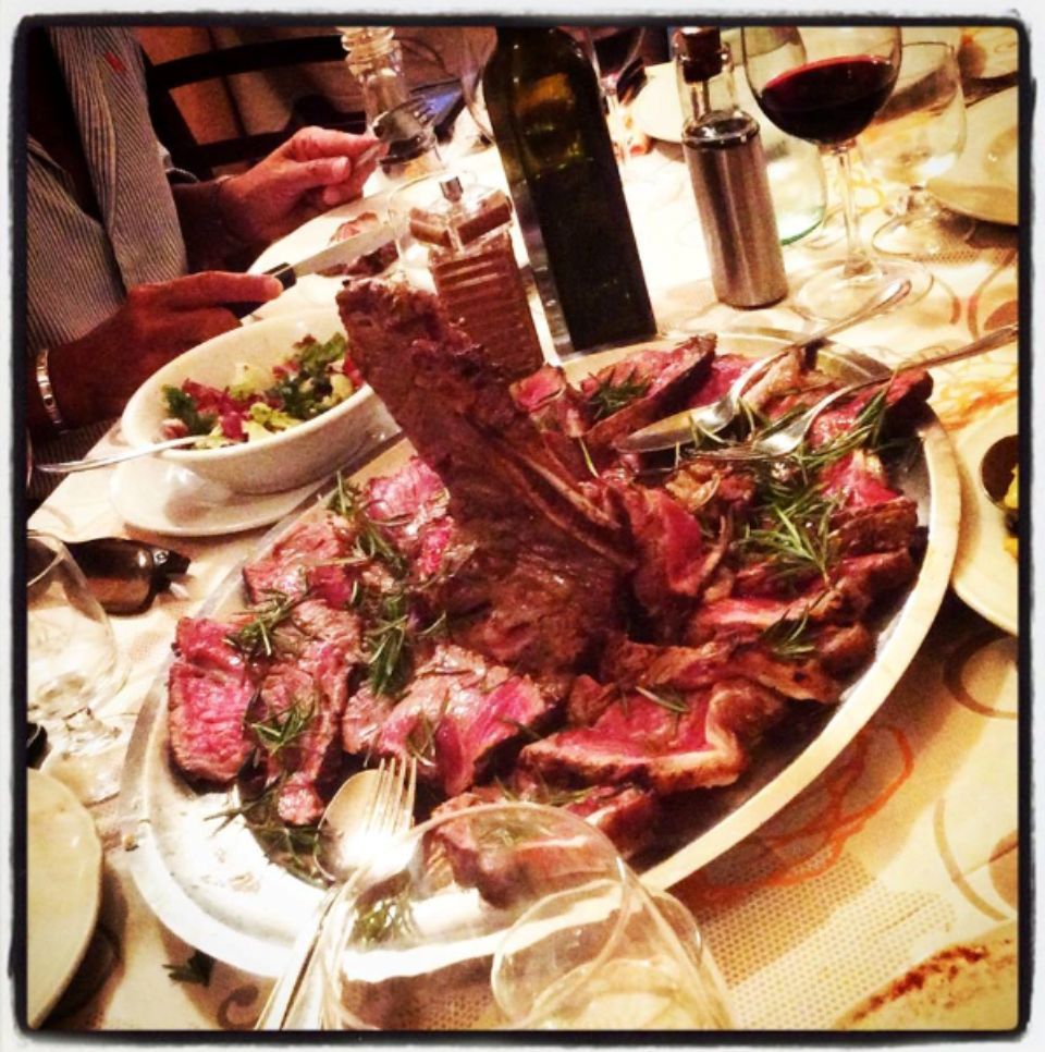 Un piatto di carne e una bottiglia di vino su un tavolo