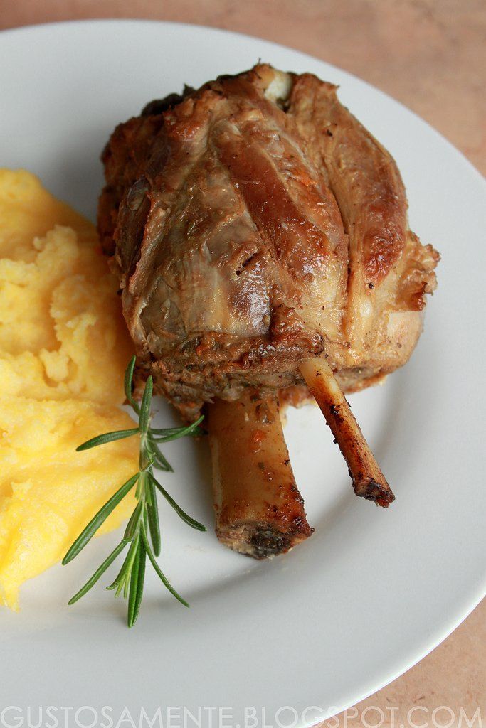 Un piatto bianco sormontato da un pezzo di carne e purè di patate