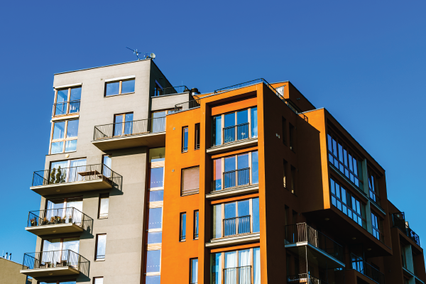 A large apartment building with a blue sky in the background