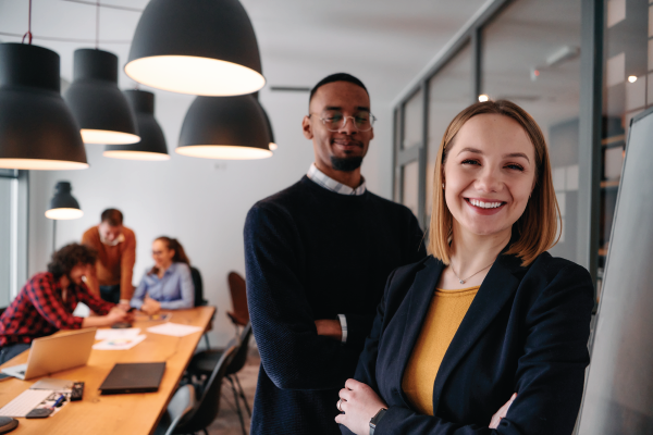 A man and a woman are standing next to each other in an office.
