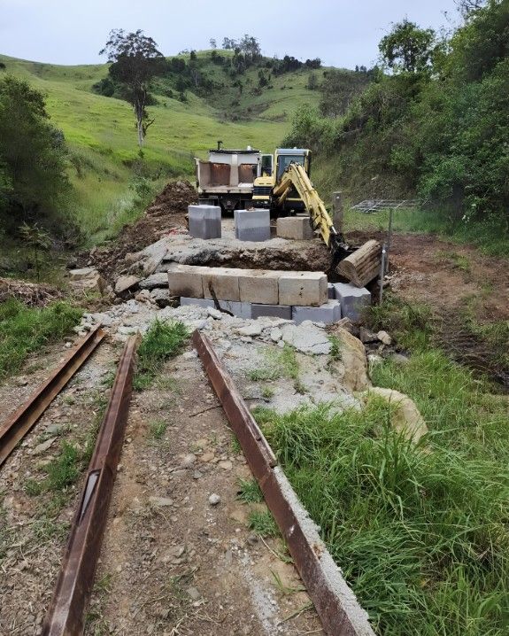 A Yellow Excavator is Working on a Construction Site — Barrington Coast Contracting in Minimbah, NSW