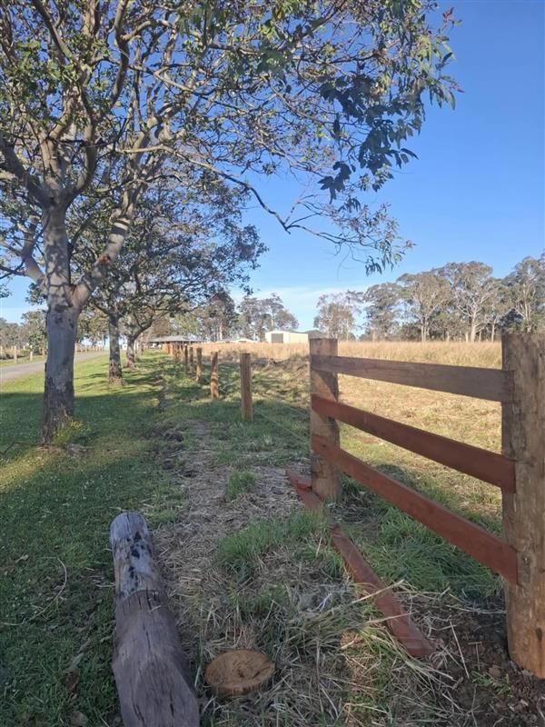 A Fence is Surrounding a Grassy Field — Barrington Coast Contracting in Minimbah, NSW