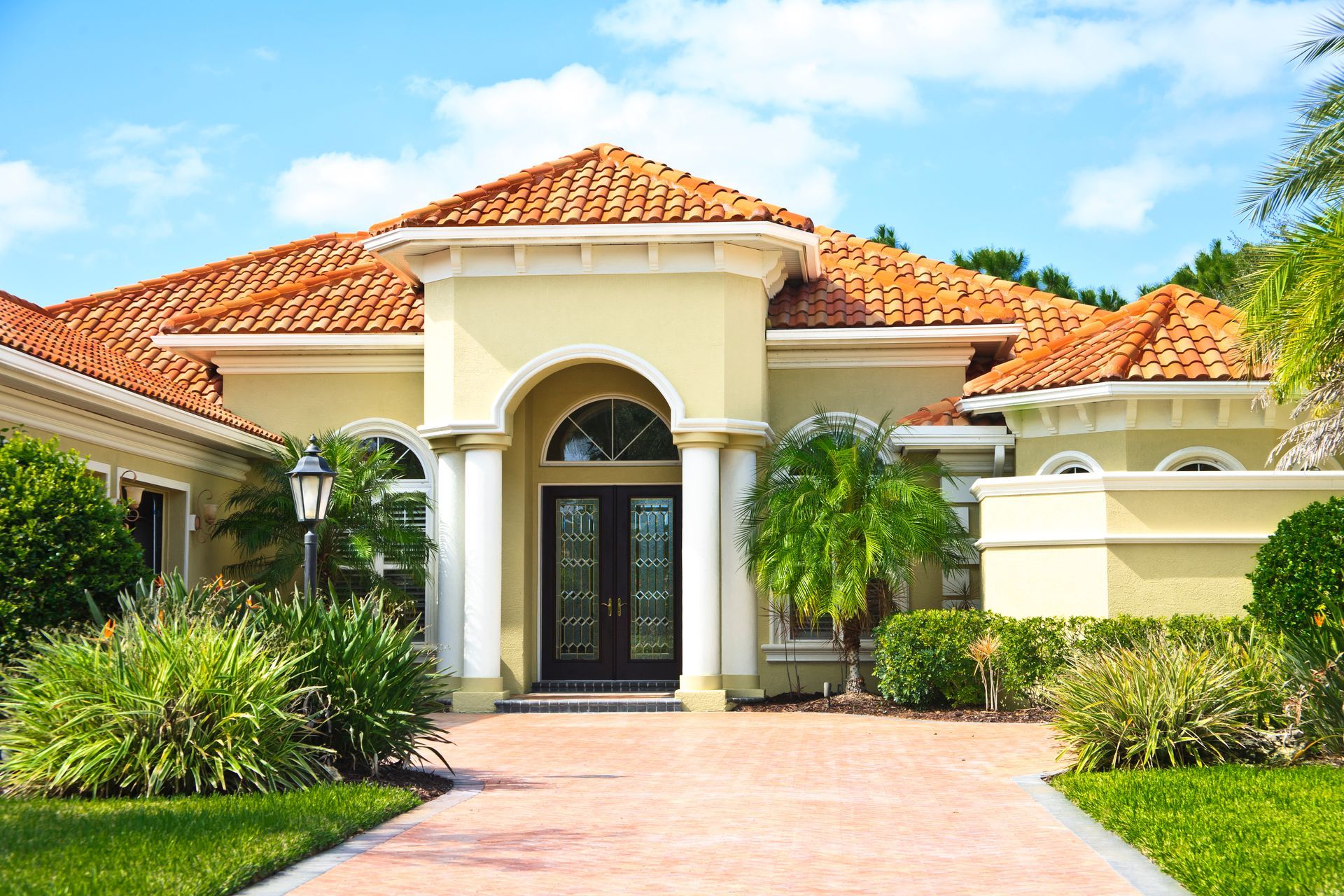 A large house with a brick driveway leading to it
