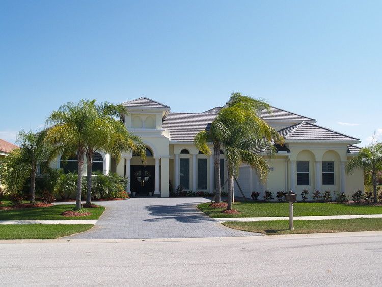 A large white house with palm trees in front of it