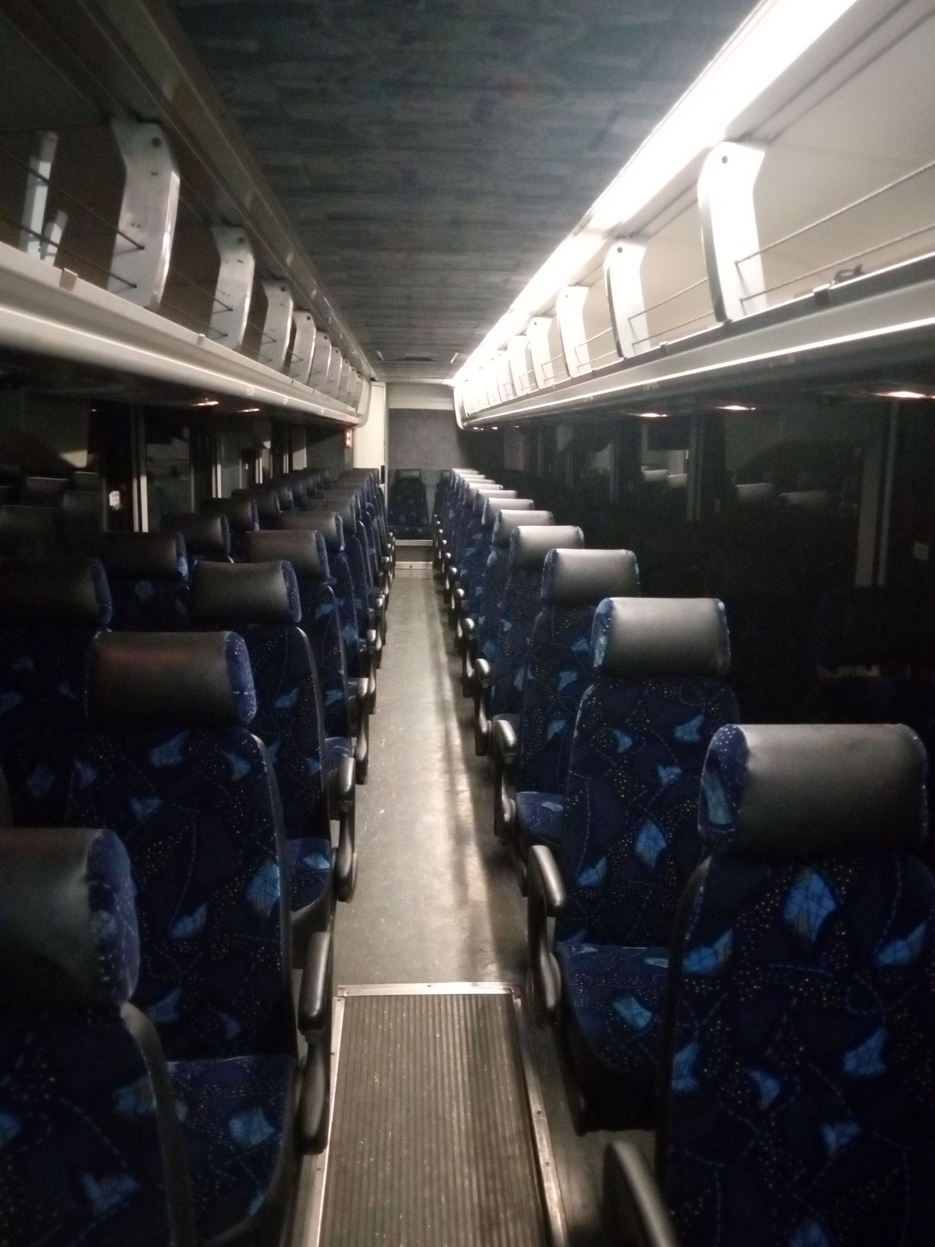 Four white buses parked in a row