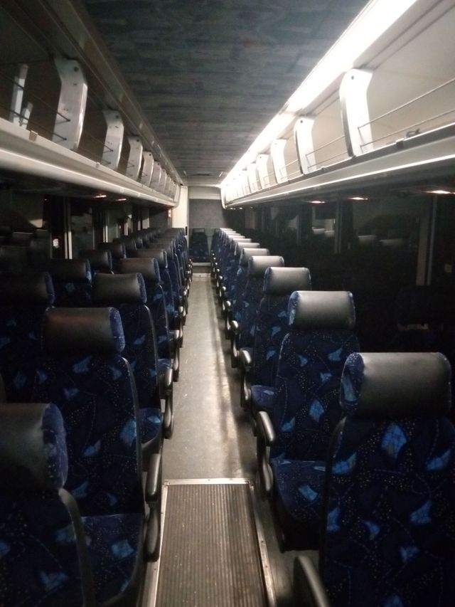 Four white buses parked in a row
