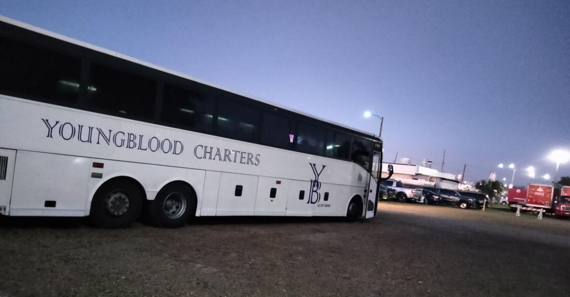 Rear view of a white tour bus on a road.