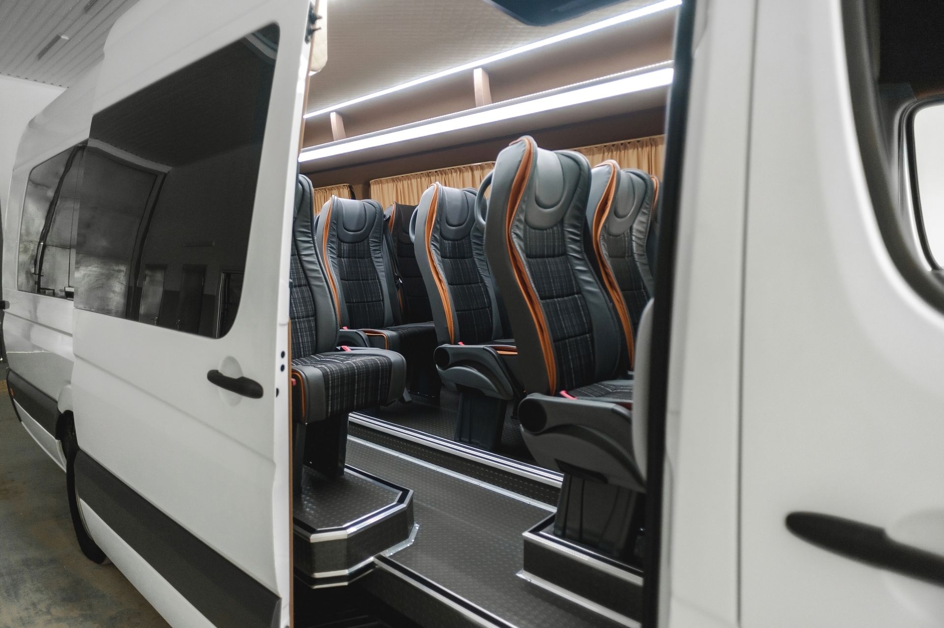 White van interior with rows of dark leather seats