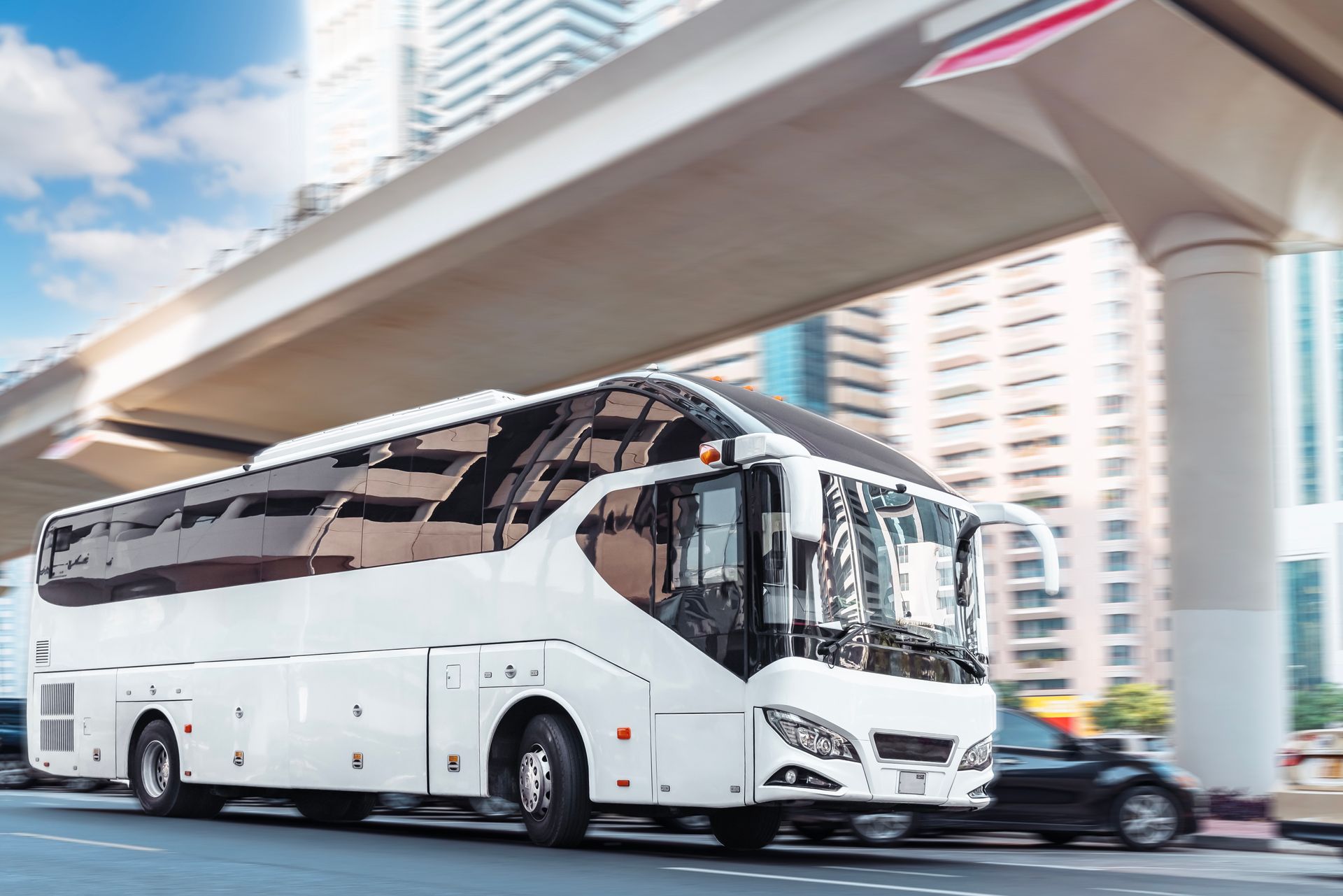 White tour bus driving on a city street