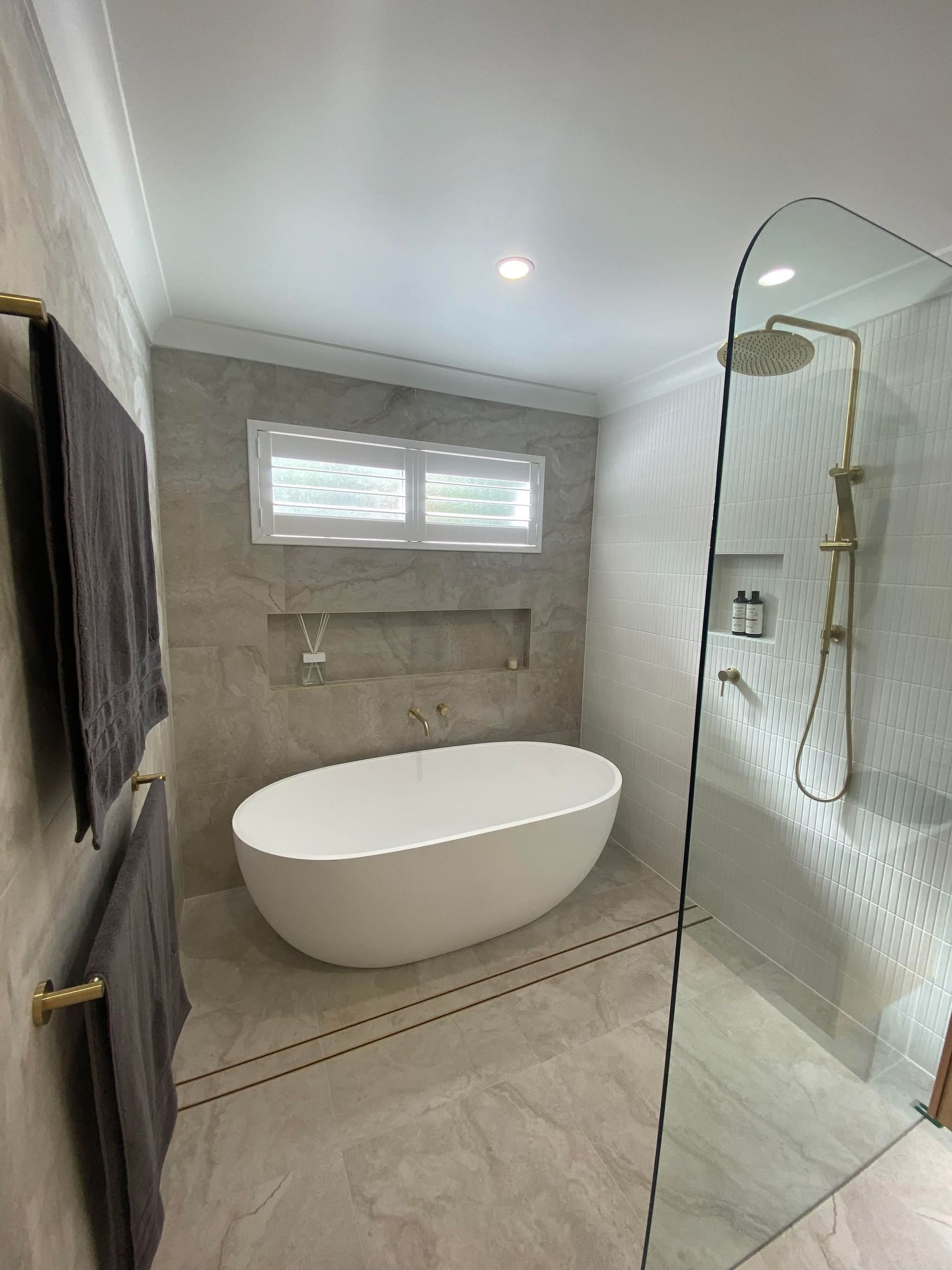 A Bathroom With A White Bathtub and Earthy Tones— Holloway Brothers In Tweed Heads, NSW