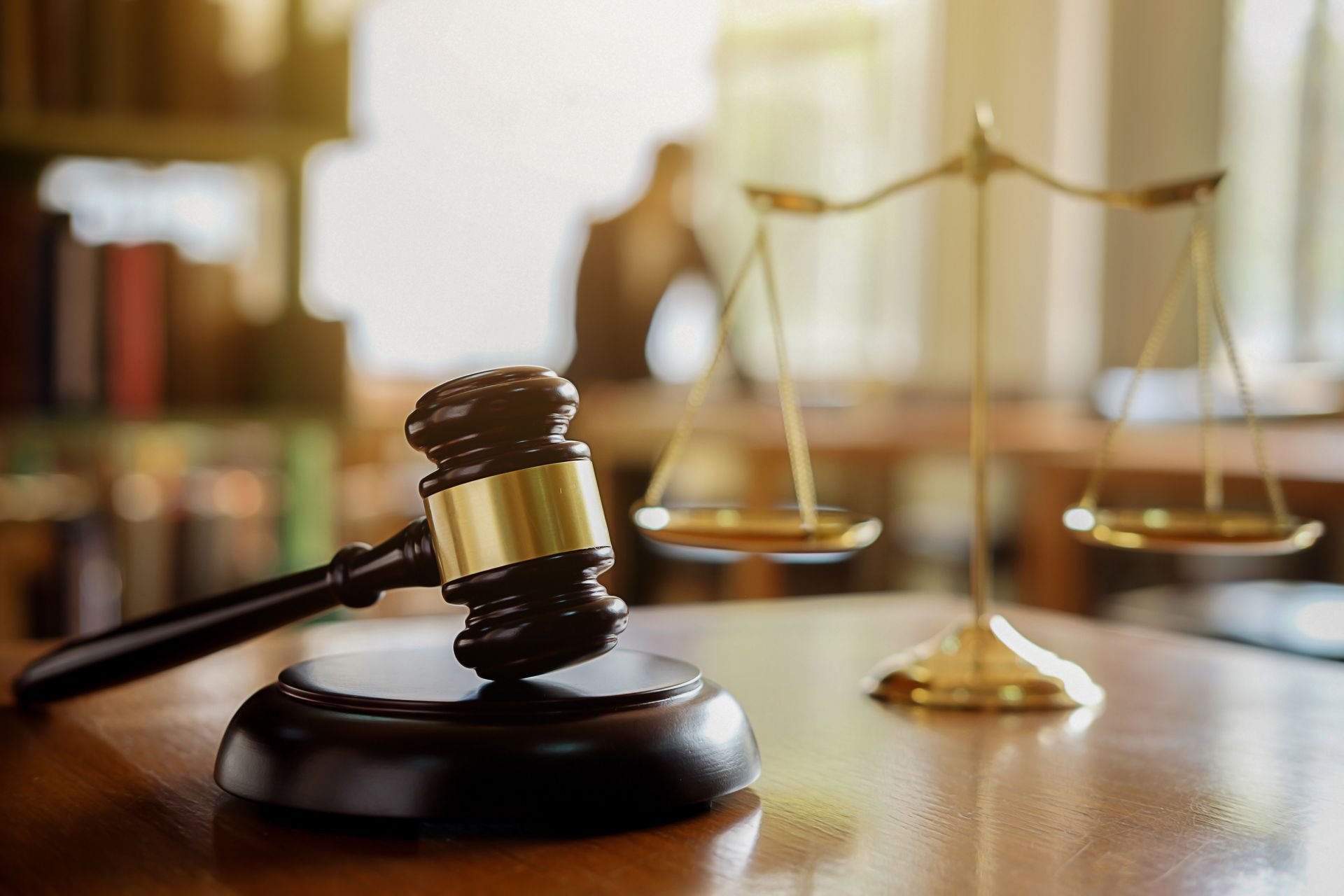 A judge 's gavel and scales of justice are on a wooden table.