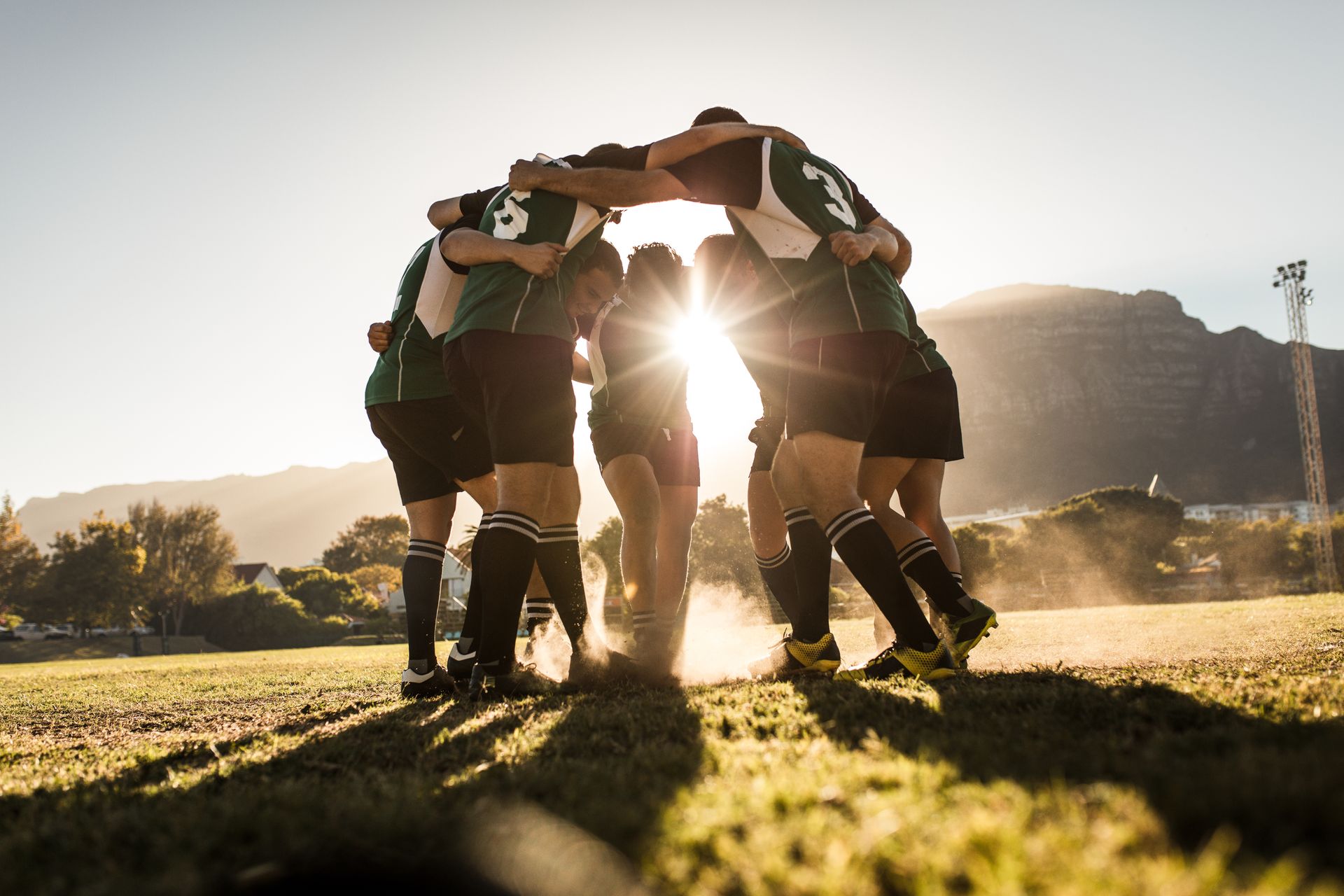 A group of rugby players are huddled together on a field.