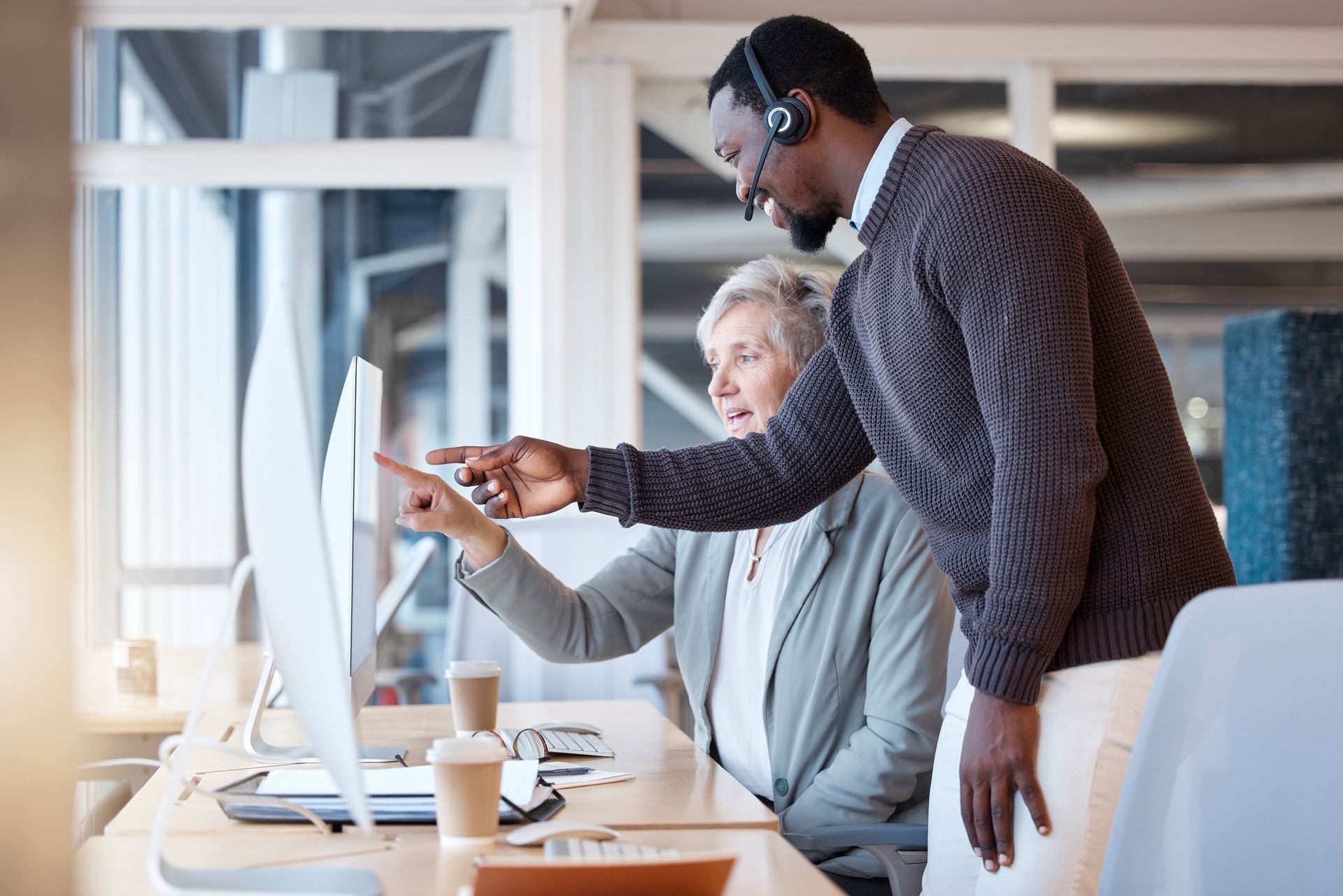 A man and a woman are looking at a computer screen.