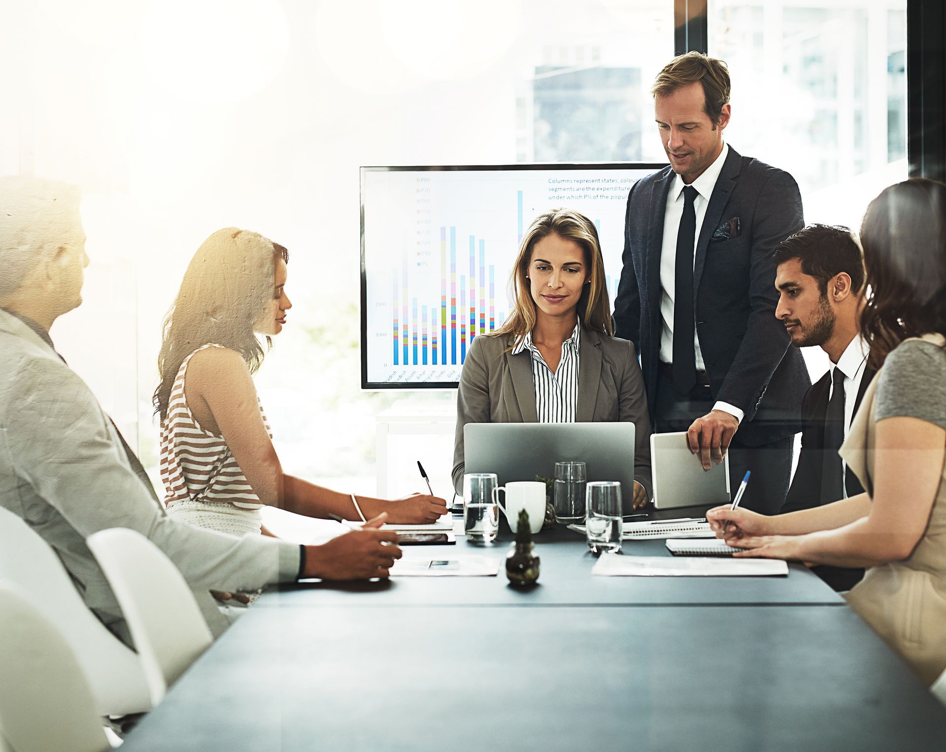 A group of business people are sitting around a conference table having a meeting.