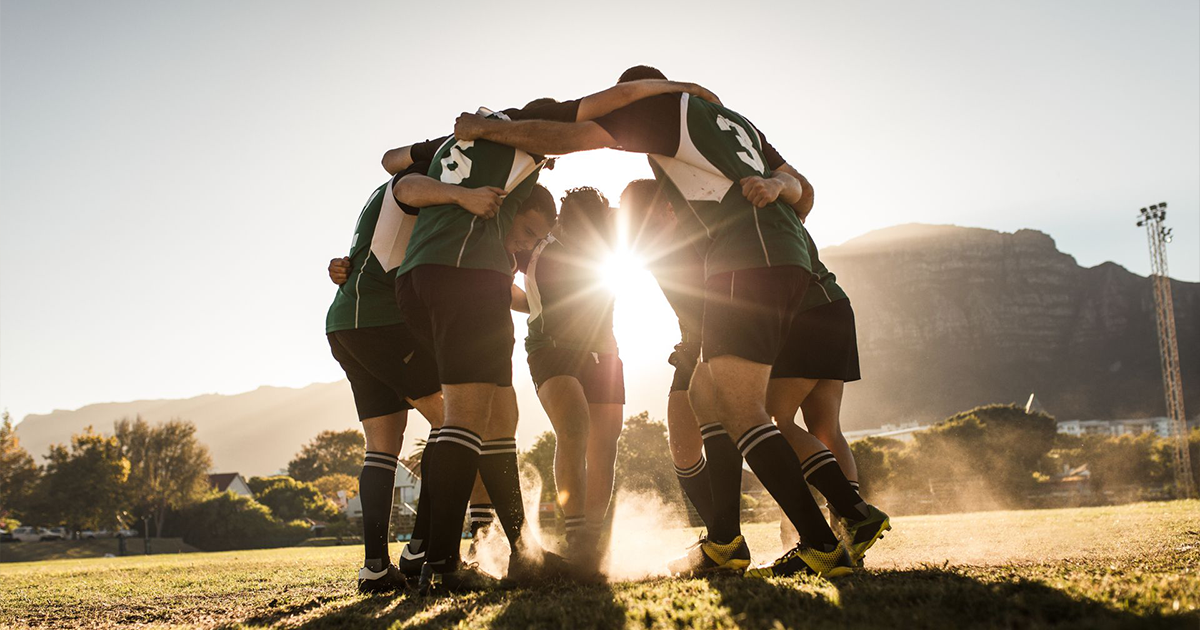A group of rugby players are huddled together on a field.