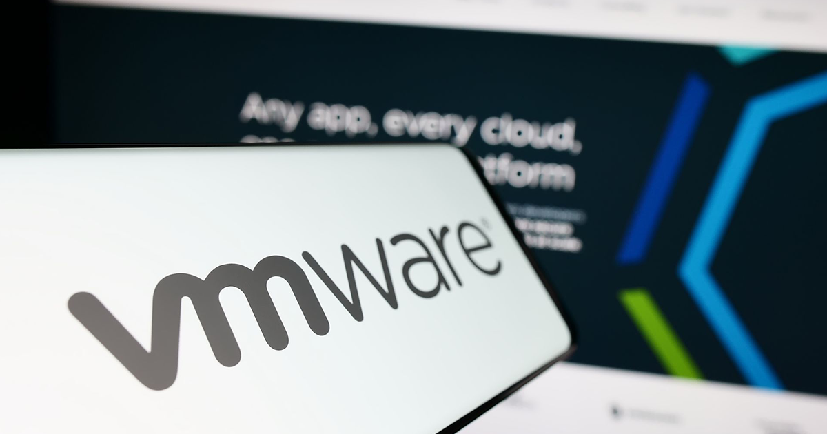 VMware logo on a smartphone screen, with a computer screen displaying VMware's tagline: 