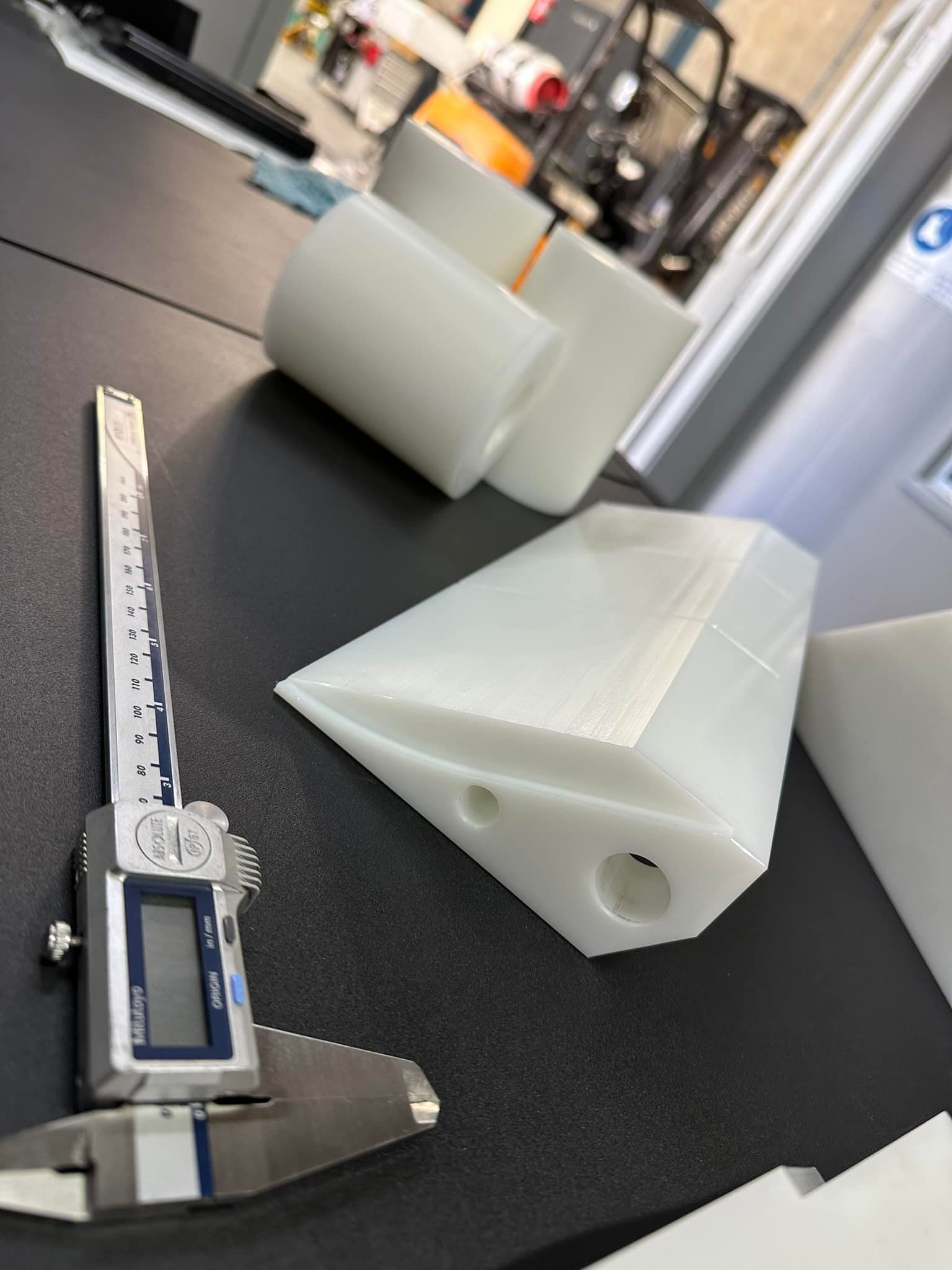 A Digital Caliper Is Sitting On A Table Next To A Piece Of Plastic — D.E.M Solutions Pty Ltd In Caboolture, QLD