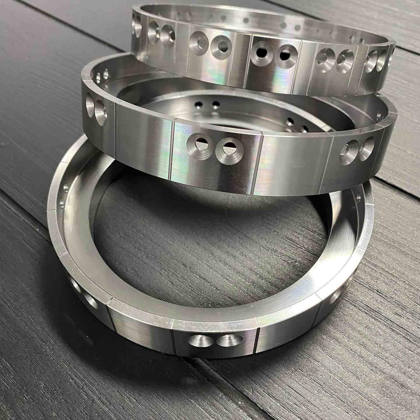 Three Metal Rings Are Stacked On Top Of Each Other On A Wooden Table — D.E.M Solutions Pty Ltd In Caboolture, QLD