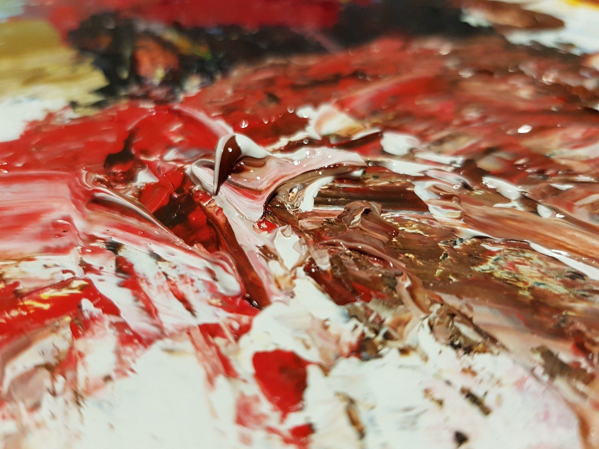 Een close-up van een schilderij met rode en witte verf op een palet.