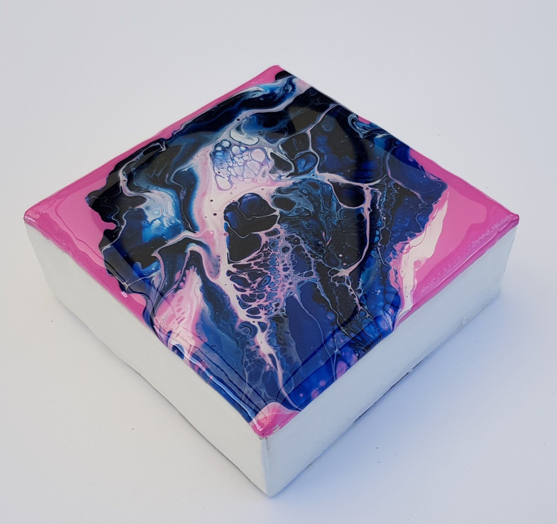 Een roze en blauw schilderij op een wit oppervlak