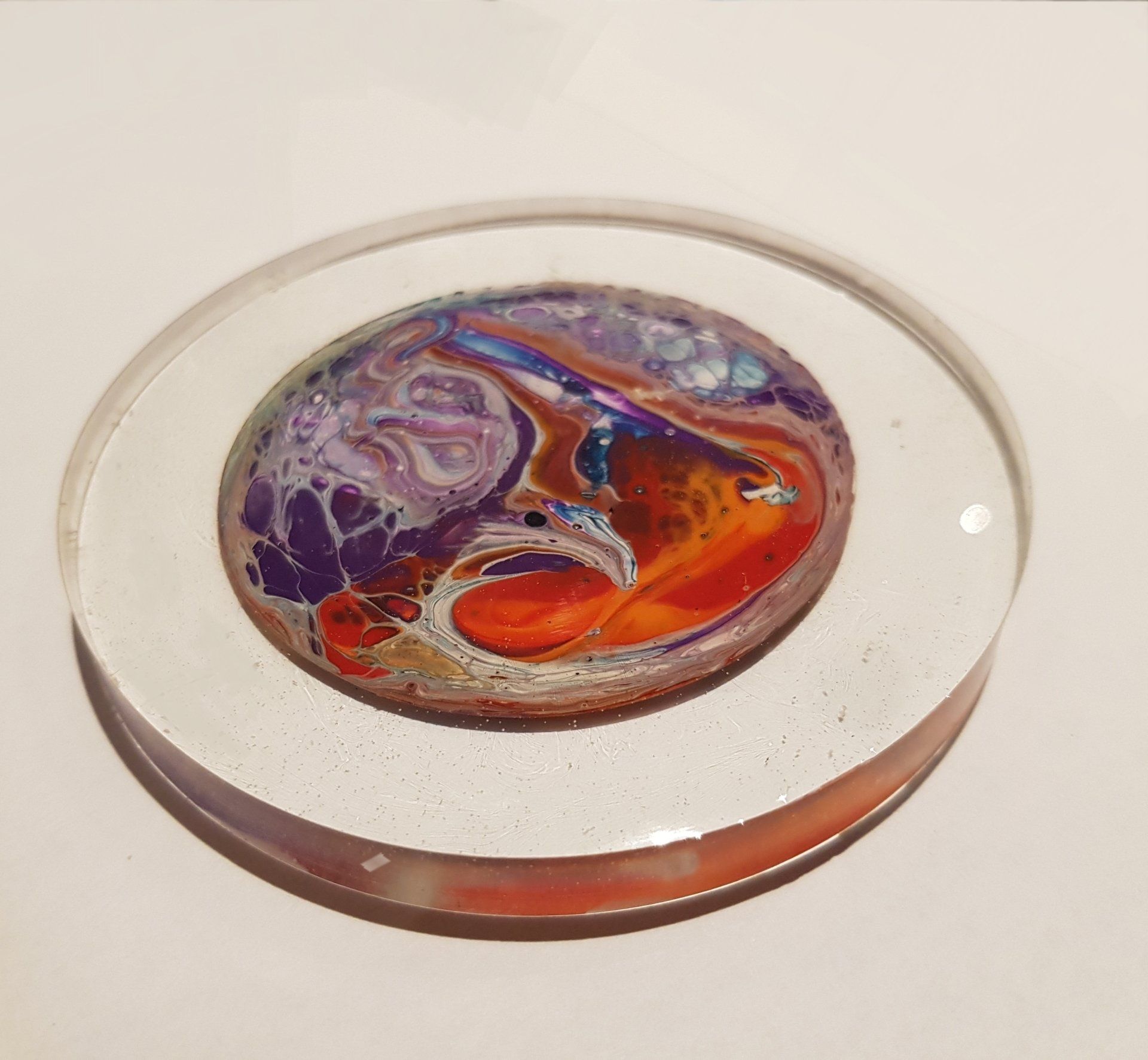 Een glazen cirkel met een kleurrijk ontwerp erop